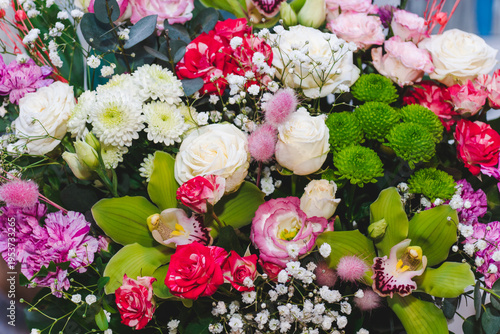 Different types of white, pink roses, and other flowers in floral arrangement.