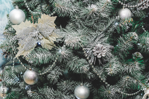 The Christmas tree is decorated with silver-colored toys.