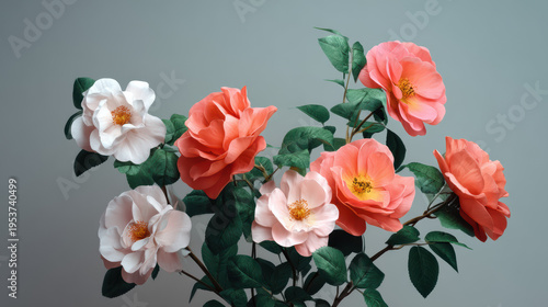 A beautiful arrangement of peach, coral, and white roses with lush green leaves creates a captivating floral display against a soft gray background in studio.