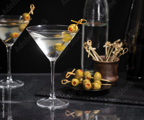 Dirty martini with olives on a pick on a dark background