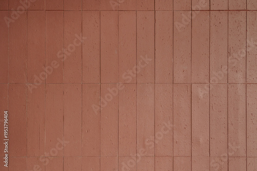 Vertical red terracotta tile wall texture. Modern architectural background with brick pattern and textured clay surface.