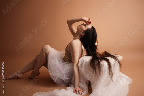 Quadro su tela Elegant young woman with long wavy dark hair posing in a professional photo stud