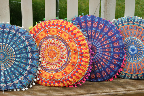 Decorative Circular Coloured Cushions  on Wooden Bench in Close Up 