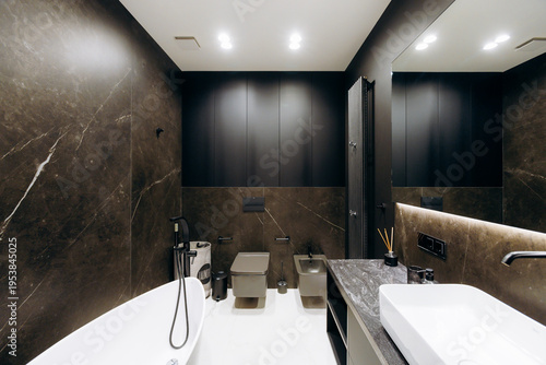 Upscale bathroom featuring freestanding tub and polished stone walls
