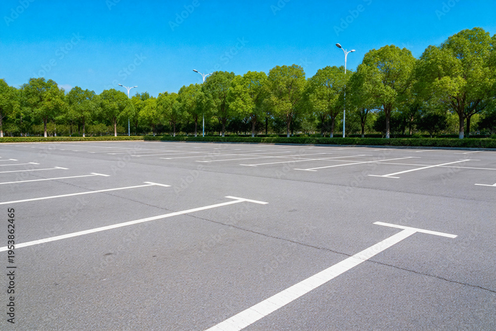 Obraz premium Empty Parking Lot with Green Trees and Clear Sky