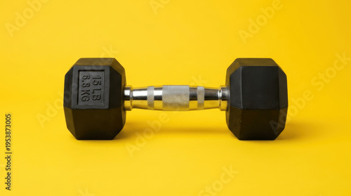 Single Hexagonal Rubber Dumbbell on a Bright Yellow Background