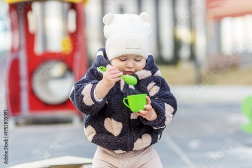 Toddler Playing With Toy Spoon Outdoors. Childcare