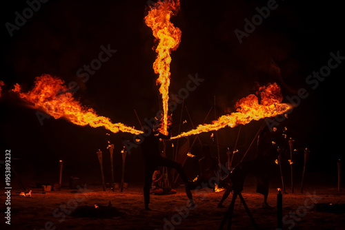 Foto Silhouette Thai performers show fire breathing and spinning on beach
