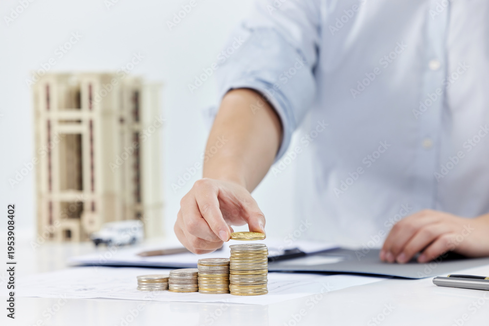 Fototapeta premium Real Estate Investment Growth - Businessman Stacking Coins with House Model