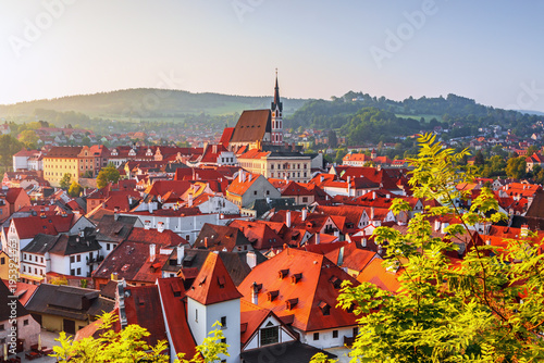 A stunning aerial drone view of Cesky Krumlov in the Czech Republic, showcasing its historic old town, red rooftops, and the winding Vltava River. This UNESCO World Heritage site features picturesque 