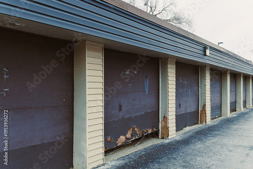 Fotografie Old storage units lined up at a commercial site with damaged doors in a North Am