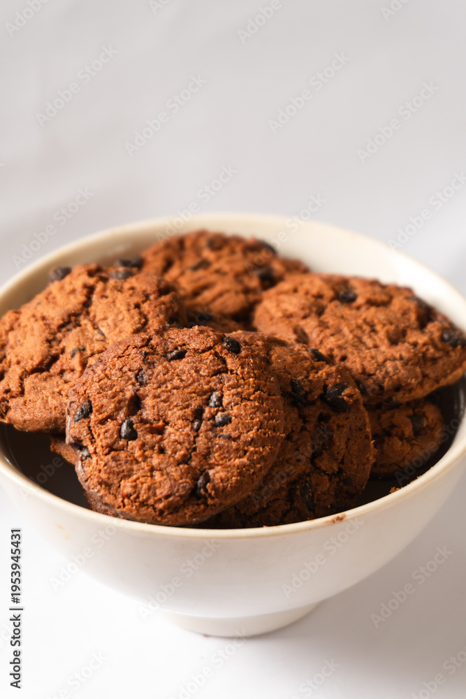 Fototapeta premium Close-up shot of dry chocolate cookies in a white bowl.