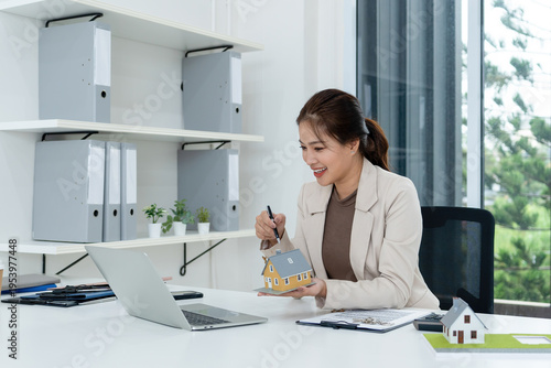 Real Estate Agent Pointing at House Model during Video Call