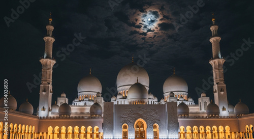 Sheikh zayed grand mosque at night with illuminated domes and minarets under a full moon