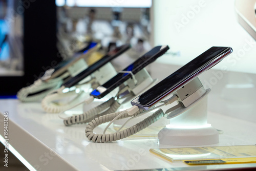 Showcase with smartphones in the modern electronics store. Buy a mobile phone. Many smartphones on the shelf of the technology store
