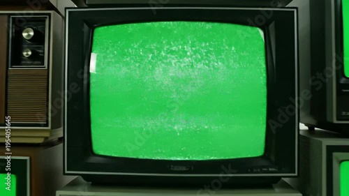 Stacked vintage television sets with green screens for advertising or graphics