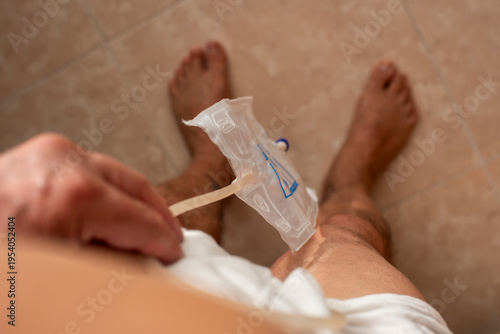 Man Using Urinal Device in Bathroom – Healthcare and Hygiene Concept
