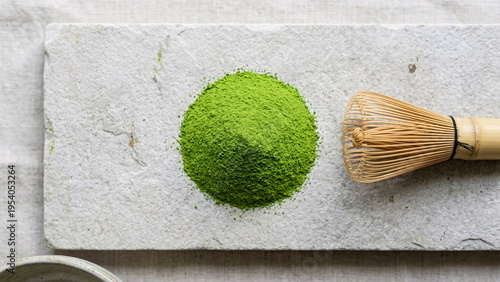 Top down flat lay of vibrant green ceremonial matcha powder on stone