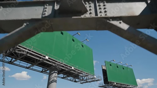 Steel structure construction support with green accents against blue sky