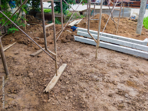 Home extension construction site with scaffolding and concrete piles.