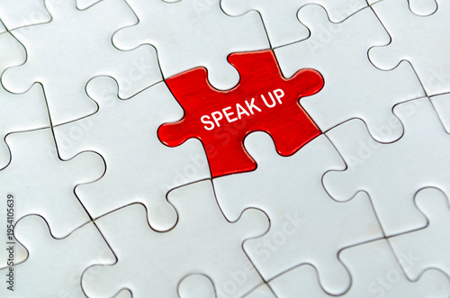 Red speak up puzzle piece placed alone in the center of a white jigsaw puzzle background.