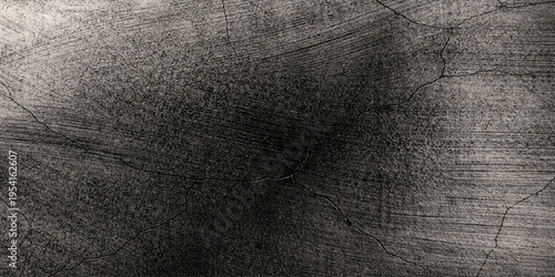 A close up view of a dark and weathered concrete surface featuring deep cracks and rough texture