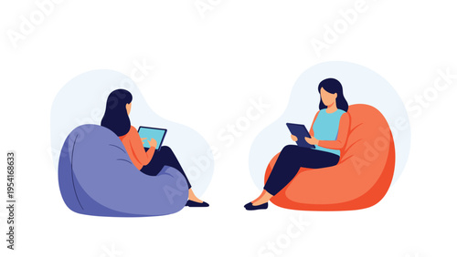 Two young women relaxing in comfortable bean bag chairs while using their digital tablets for work or leisure activities.