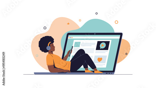 Relaxed man with an afro lounges comfortably while using his smartphone and looking at a giant laptop screen with video content.