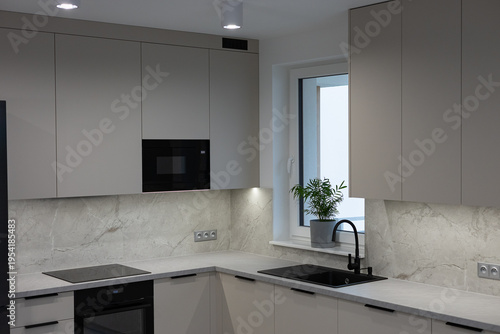 Fotografija Modern turn key apartment with minimalist kitchen design featuring grey cabinets black sink and marble backsplash