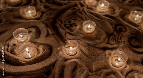 Canvas Print Glowing tealight candles set in flowing textured sand create
