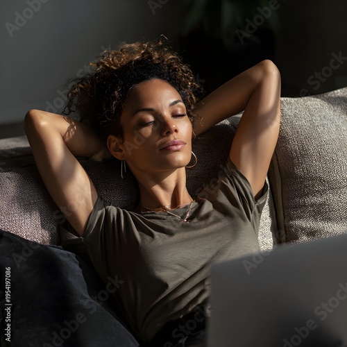 Top view of Black female professional lying on sofa using laptop relaxed posture cozy hybrid work from home environment