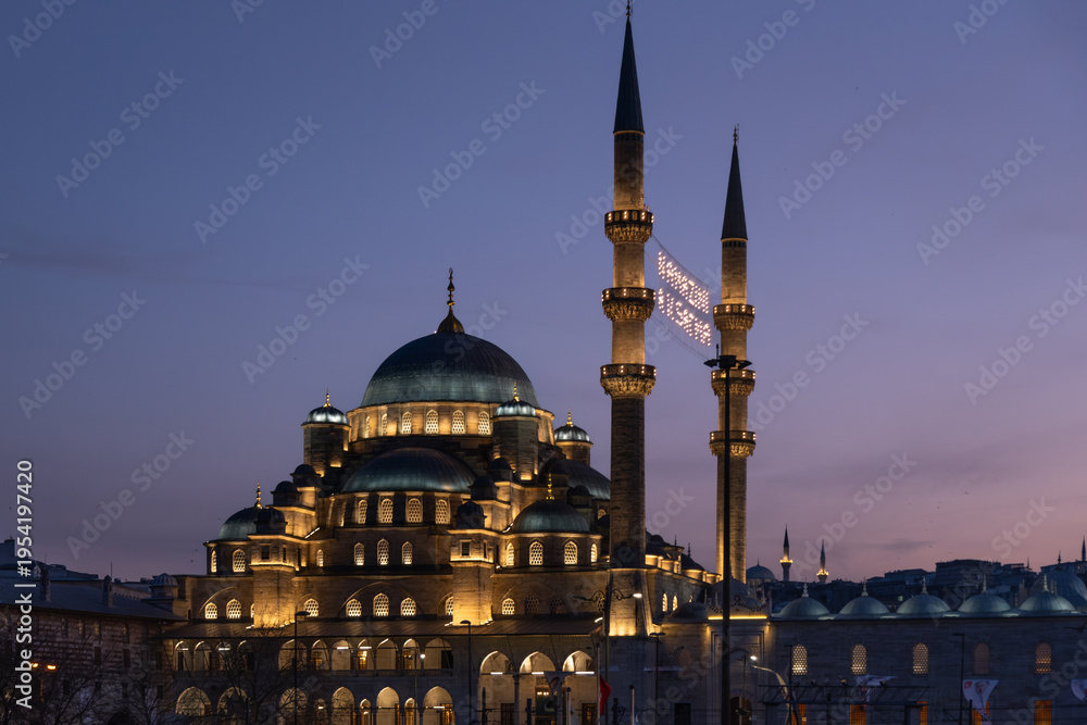 Obraz premium Grand illuminated mosque with multiple domes and soaring minaret