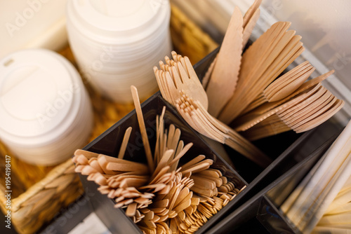Quadro su tela Top view of eco friendly wooden cutlery in organizer with paper cups, sustainabl