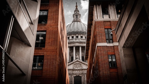 Obraz na płótnie St Paul's Cathedral dome framed between red brick buildings in narrow London all