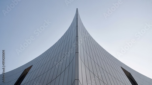 A sleek, modern building with a unique, pointed roof design