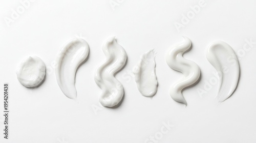 Set of six white toothpaste or cosmetic cream smears isolated on a pure white background