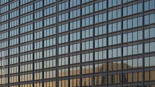 A modern office building with many windows reflecting the sky