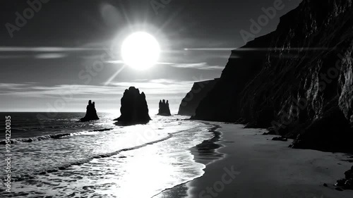 Sunset over ocean with rock formations on black sand beach