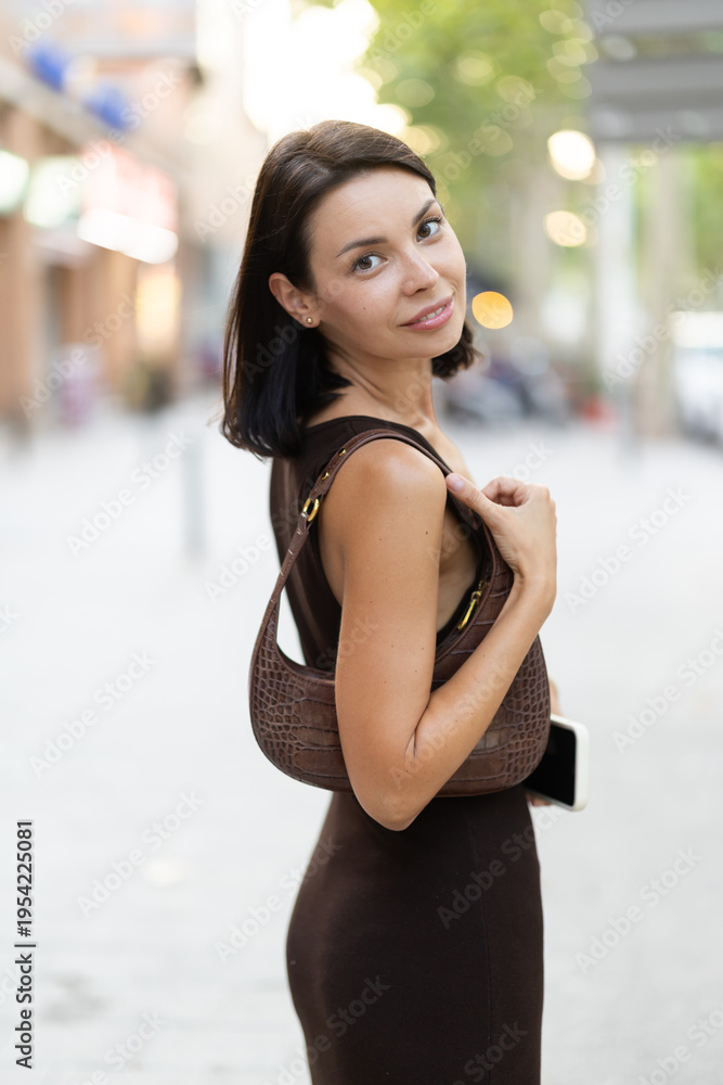 Fototapeta premium Slender female brunette walks in vicinity of Passeig Nou in Barceloneta, spends time in motion, walks and enjoys sunny warm day. Carefree, promenade