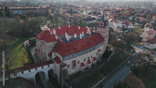 Aerial drone footage slowly approaching Brandýs nad Labem castle from the front, Czech Republic. The shot reveals the full castle facade with its Renaissance architecture, arched entrance bridge over 