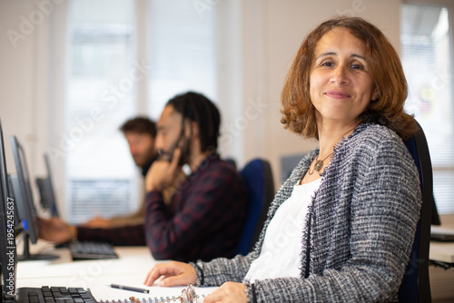 Foto portrait d'une femme salariée d'une entreprise, manager qui travaille au bureau avec ses collègues