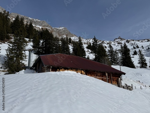Old traditional swiss rural architecture and alpine livestock farms in the winter ambience of the alpine Swiss tourist resort Davos - Canton of Grisons, Switzerland (Kanton Graubünden, Schweiz)