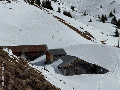 Old traditional swiss rural architecture and alpine livestock farms in the winter ambience of the alpine Swiss tourist resort Davos - Canton of Grisons, Switzerland (Kanton Graubünden, Schweiz)