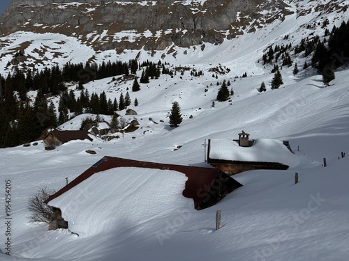 Old traditional swiss rural architecture and alpine livestock farms in the winter ambience of the alpine Swiss tourist resort Davos - Canton of Grisons, Switzerland (Kanton Graubünden, Schweiz)