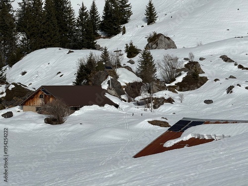 Old traditional swiss rural architecture and alpine livestock farms in the winter ambience of the alpine Swiss tourist resort Davos - Canton of Grisons, Switzerland (Kanton Graubünden, Schweiz)