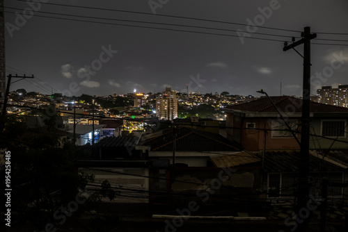 A street in the southern part of São Paulo is plunged into darkness during a blackout caused by heavy rains. The image exposes the vulnerability of urban infrastructure, where overhead wiring, visible