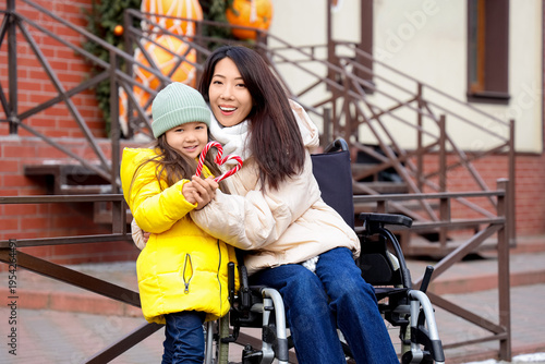 Young Asian mother in wheel...