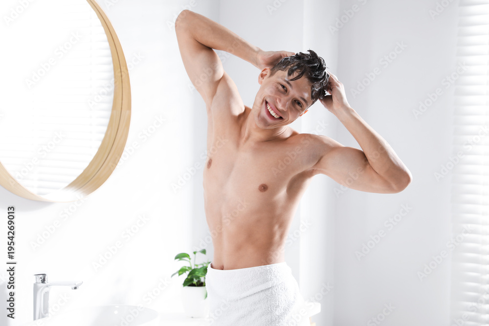 Obraz premium Man washing his hair with shampoo in bathroom