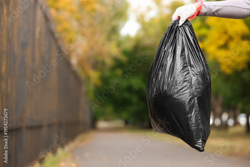 Female hand with garbage ba...