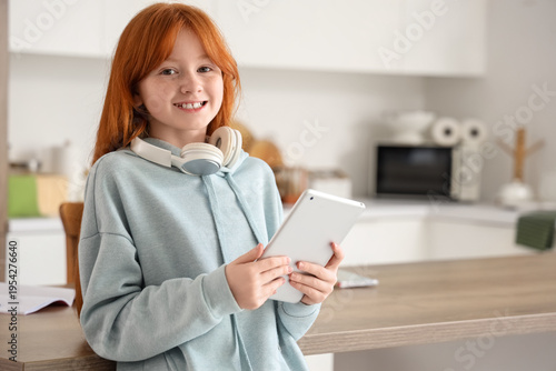Little redhead girl with ta...